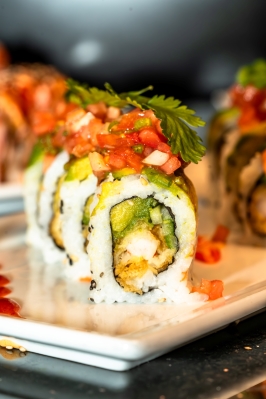 A straight-on shot of a Mexican shrimp sushi roll on a plate.