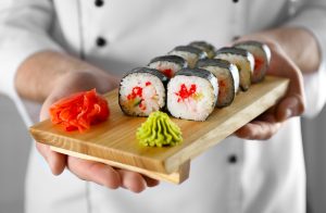 A beautiful sushi roll with a side of bright green wasabi